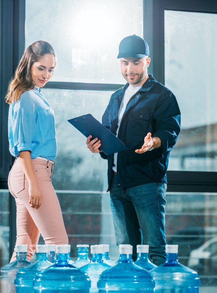 courier-with-clipboard-and-woman-looking-at-delivered-water-bottles.jpg